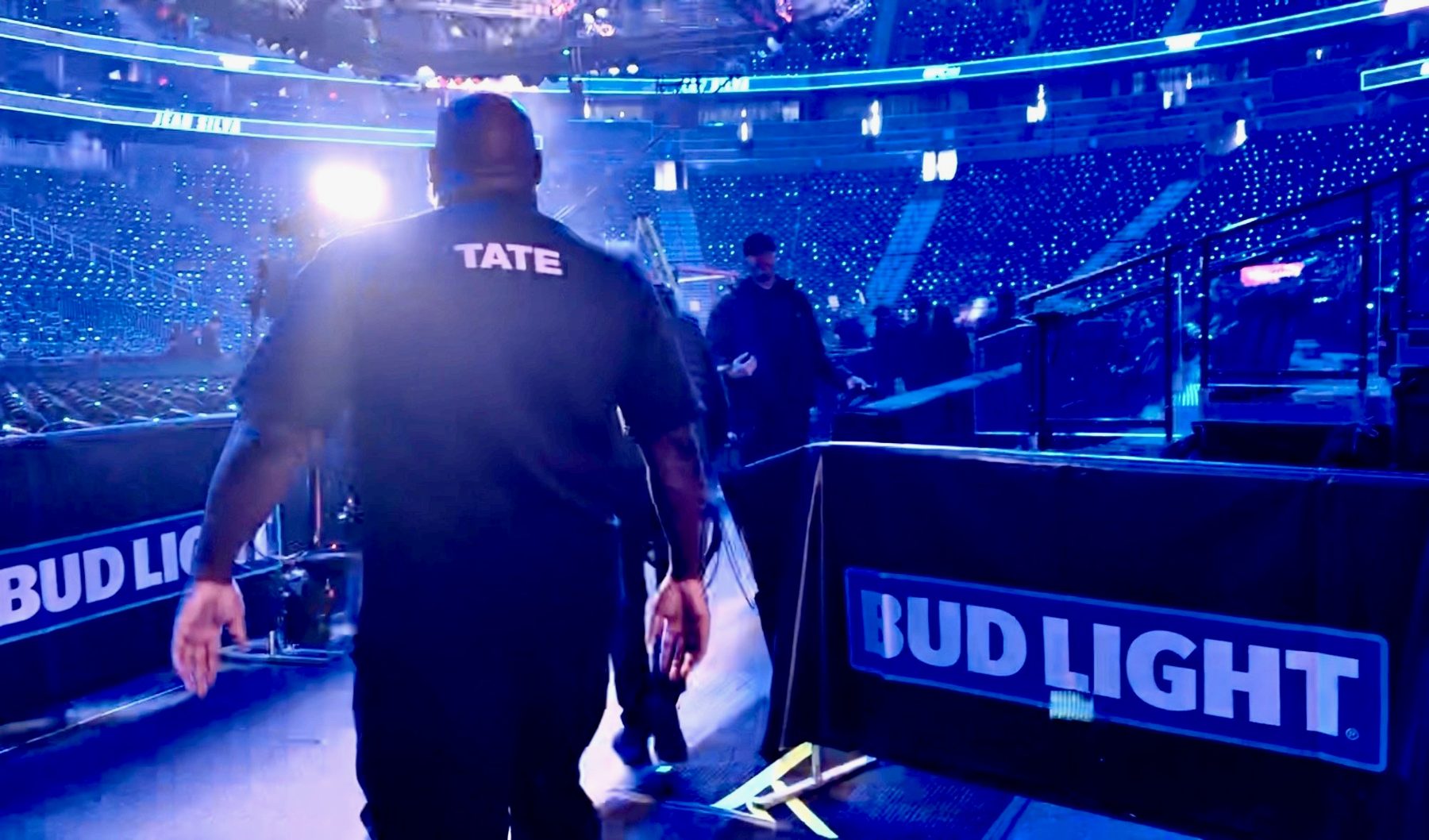 Brad Tate walking out to a professional fight arena, TATE printed on his shirt